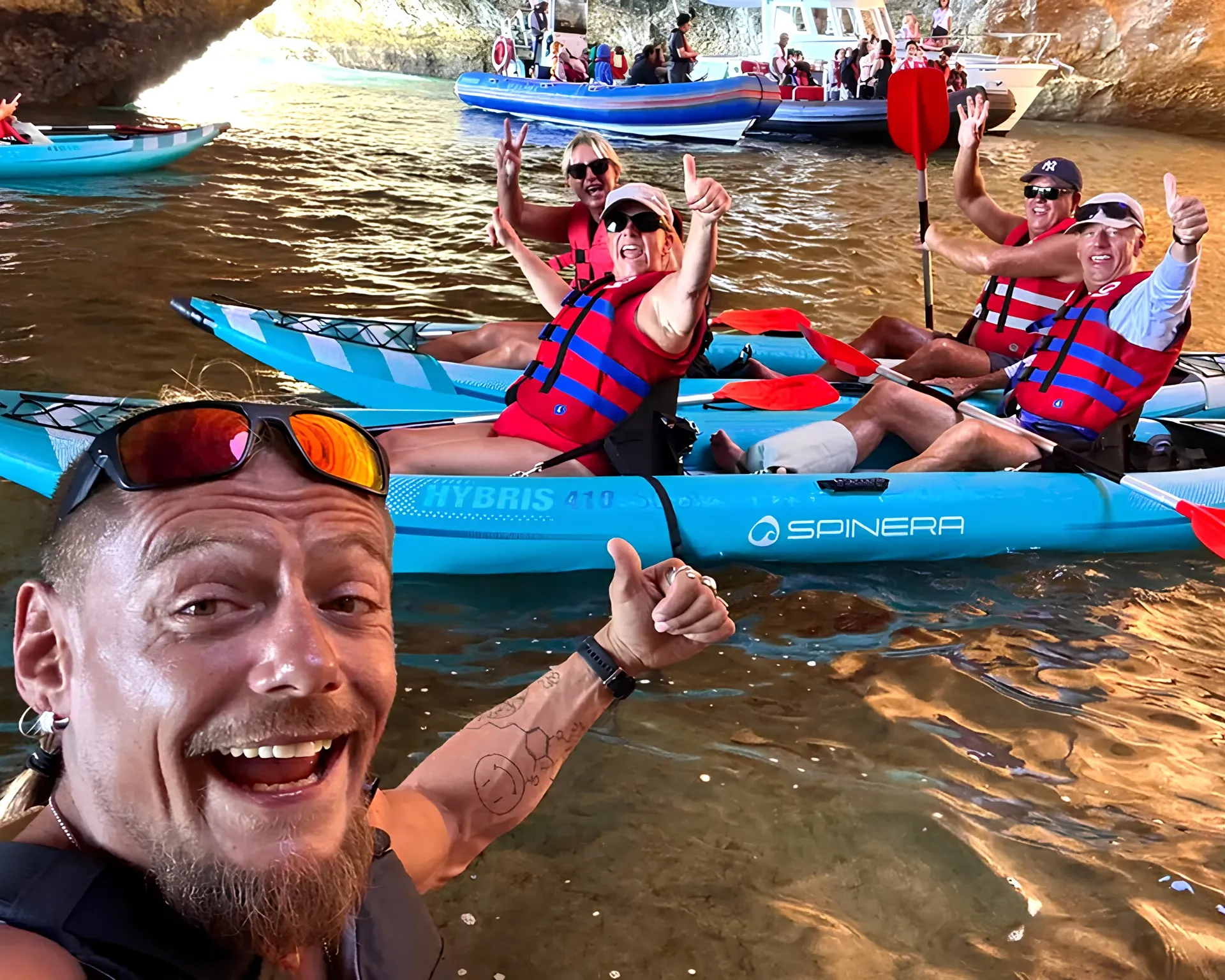 Guide taking a selfie with the tour group inside Benagil Cave – guests in kayaks with the iconic skylight visible above