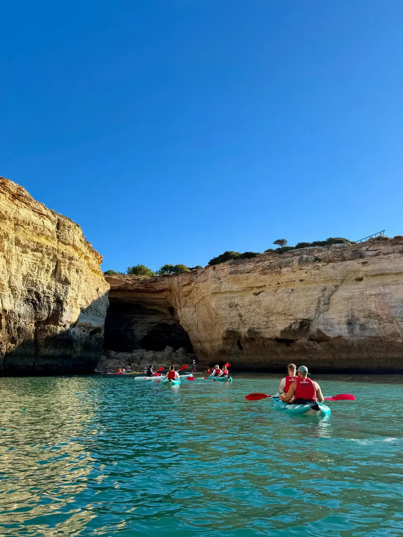 Group of kayakers heading towards a cave entrance along the Benagil coastline – guided by a local expert from Salty Cliffs