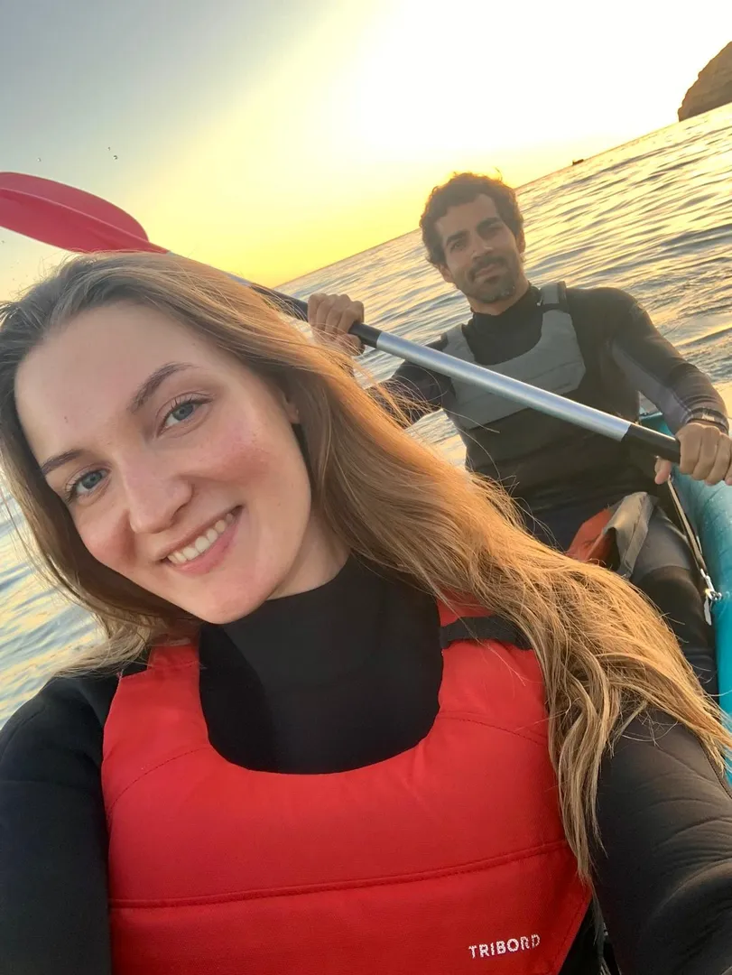 Kayak selfie taken during golden hour along the Algarve coast – warm light reflecting off the water and cliffs